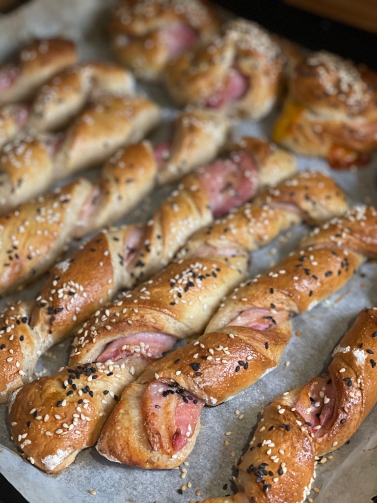 Bacon twisters/snurrer på rad og rækker. De er glinsende og gyldne--og drysset med to slags sesamfrø, for at give dem et farvespil.